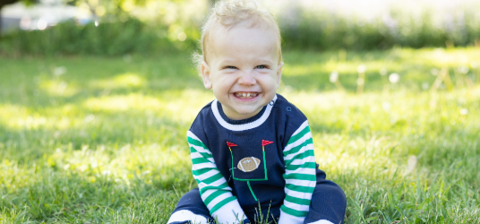 baby boy smiling outside in dog longall