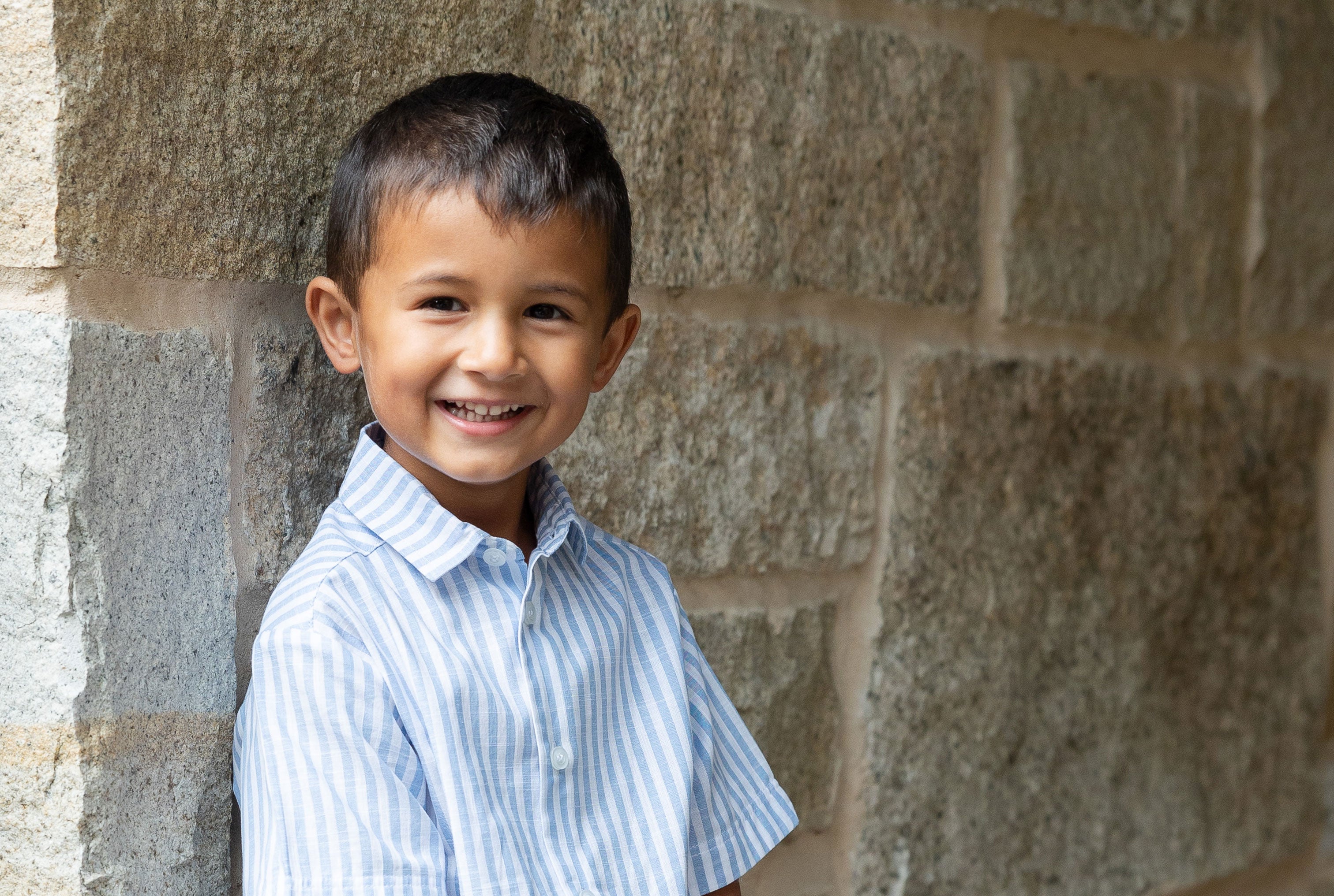 young boy in button down shirt leaning