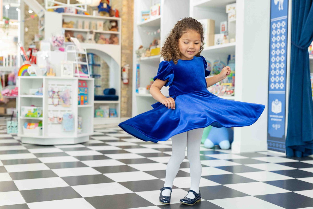 little girl dancing in a field in a floral dress