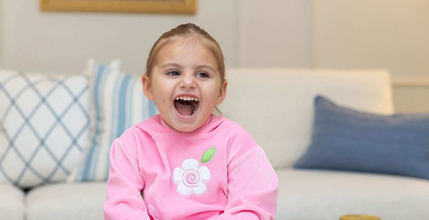 young girl in velour hoodie enjoying a book