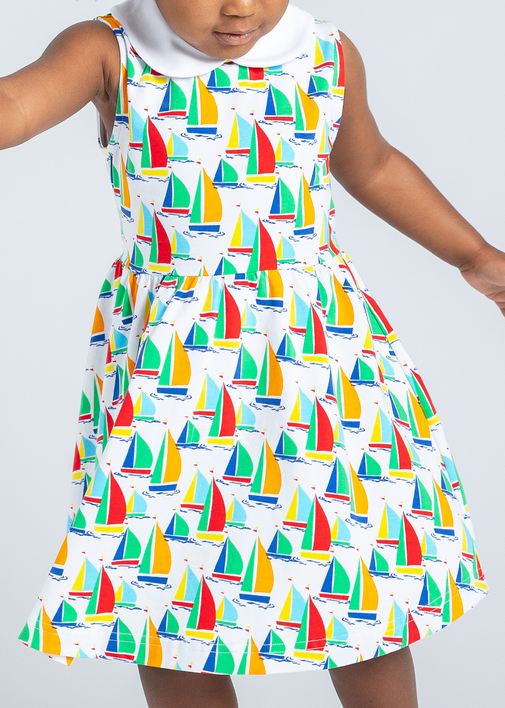 closeup of young girl in twirl dress with sailboats