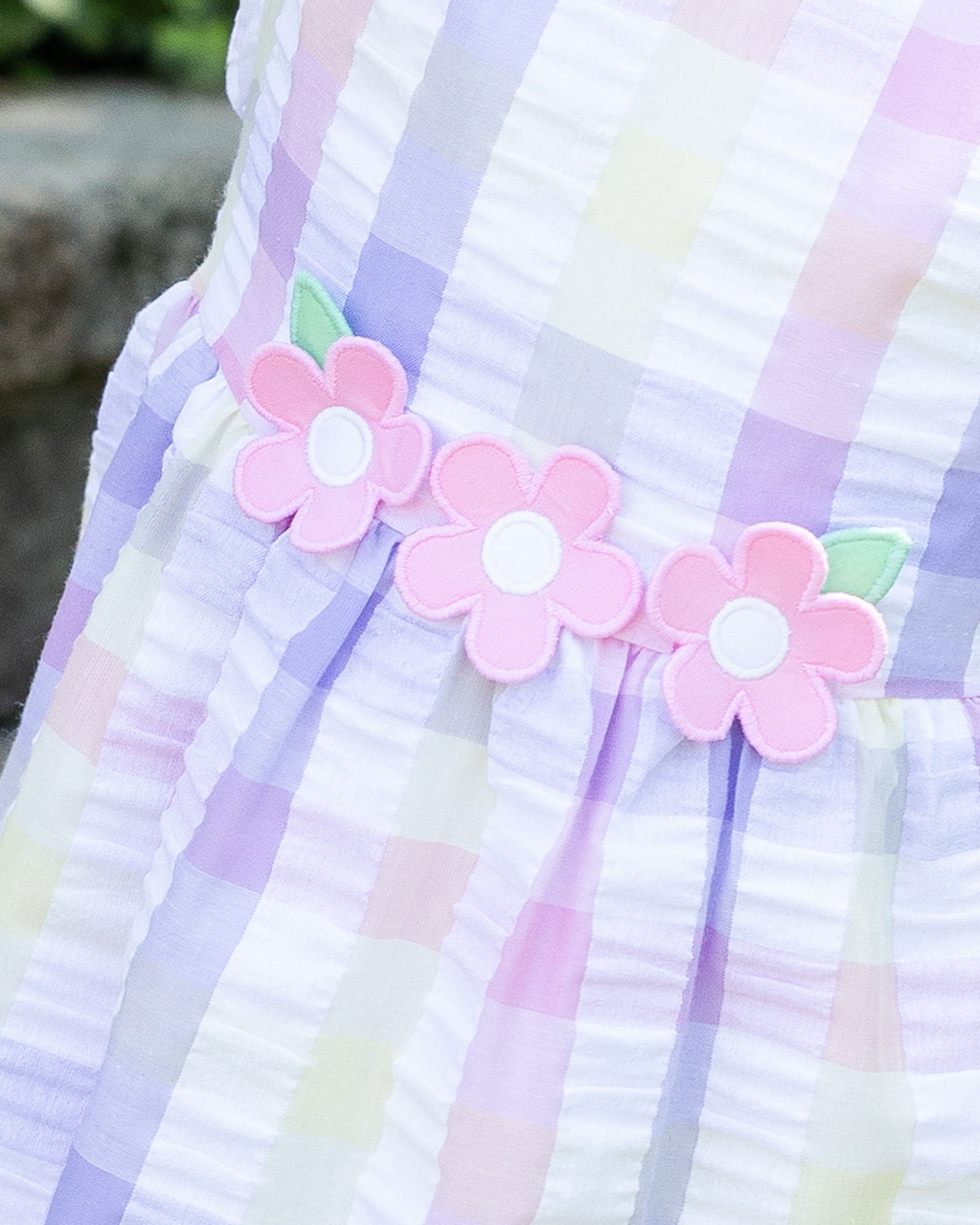 closeup of flower applique on plaid dress with flowers