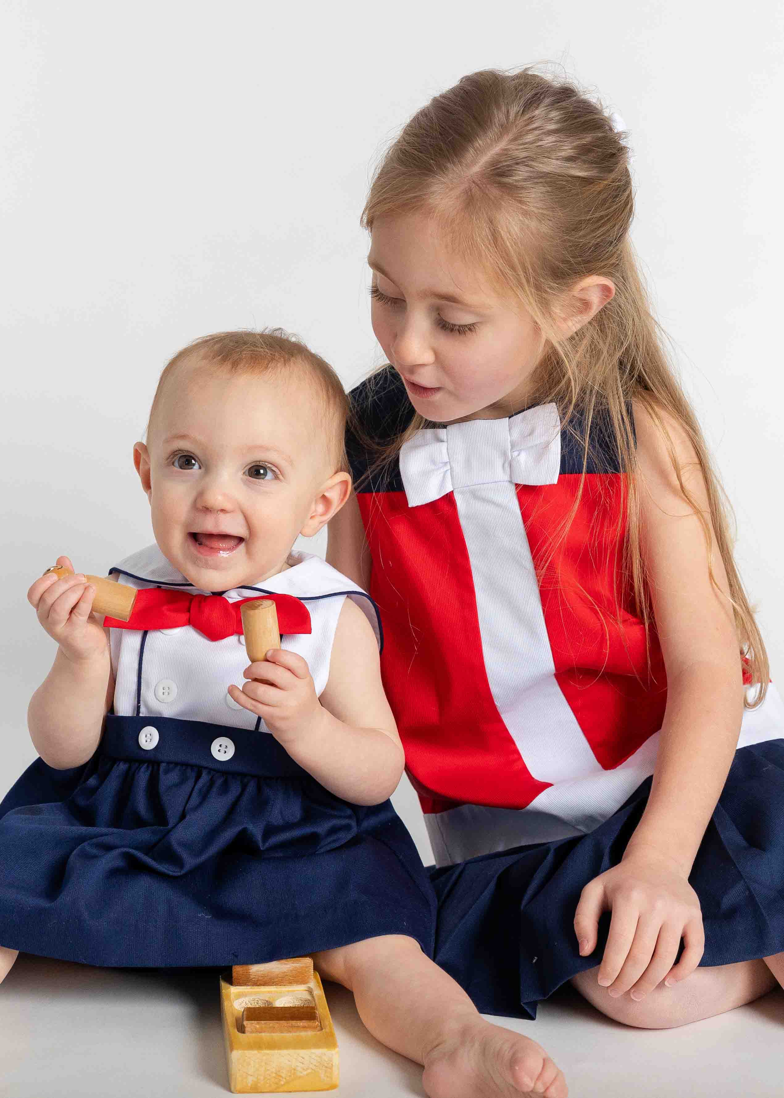 baby in romper and sister in matching dress