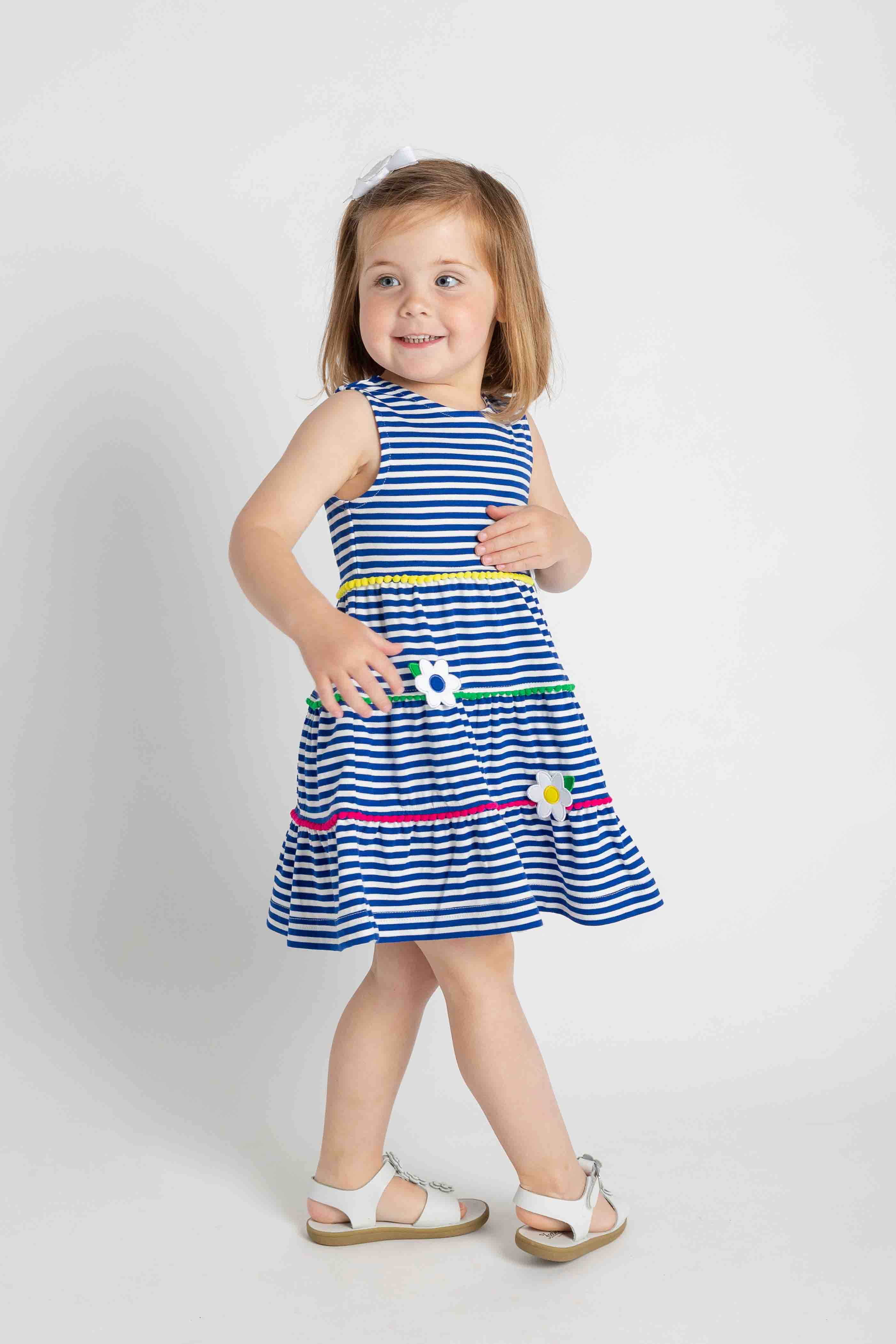 Young girl wearing a blue and white striped dress on a white background