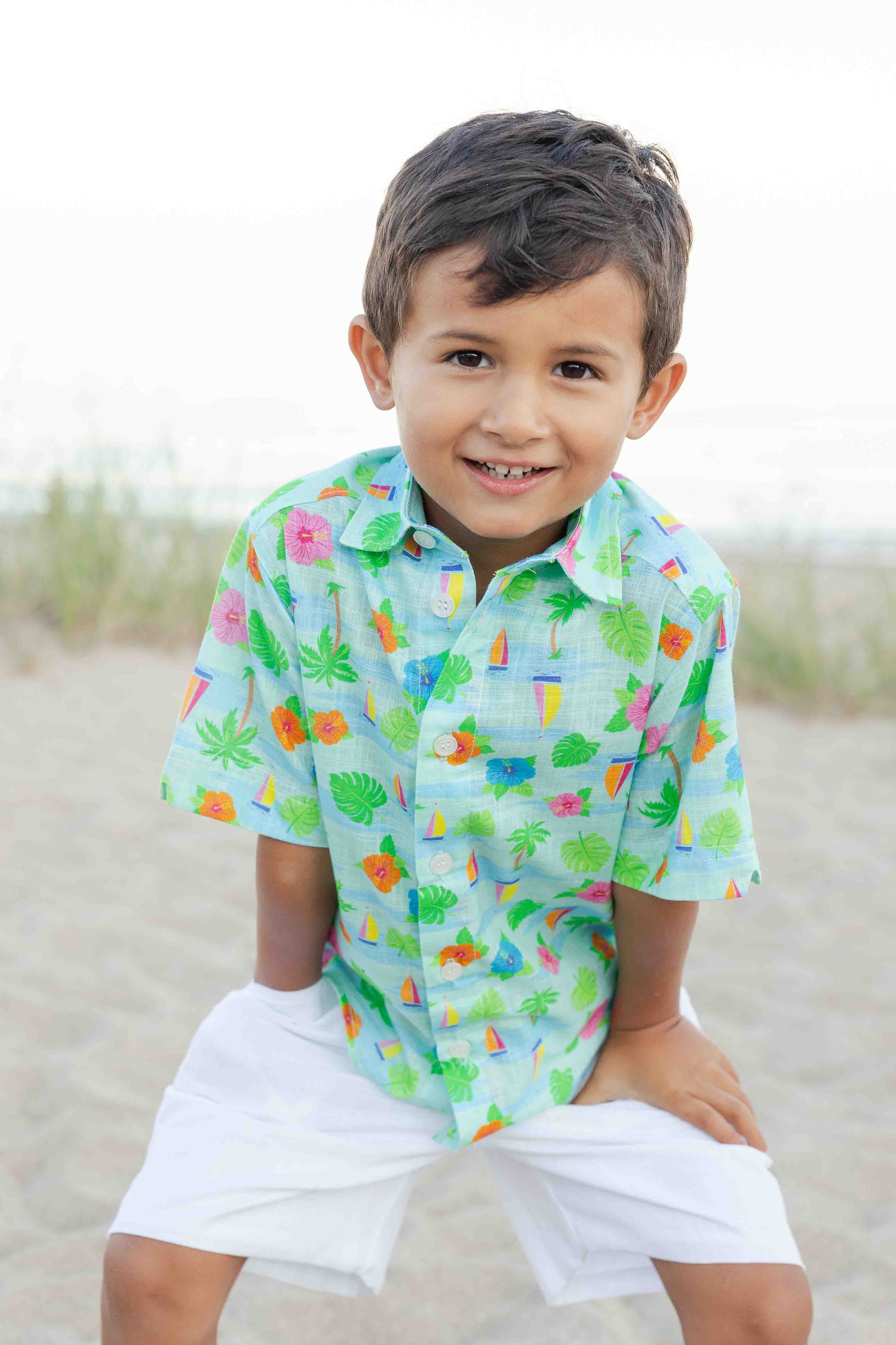 Child wearing a colorful shirt with a pattern on a beach