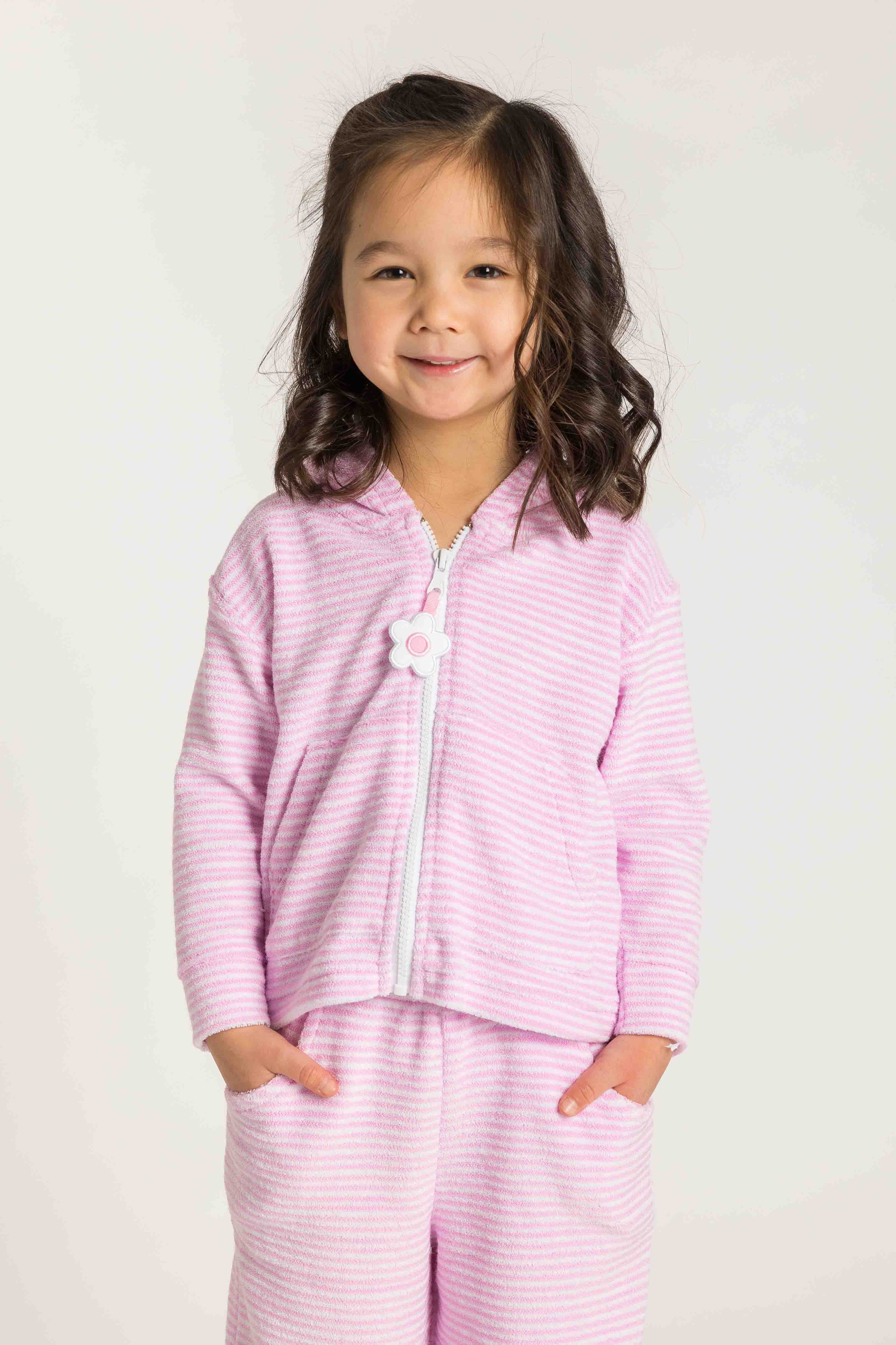 Child wearing pink striped pajamas against a plain background