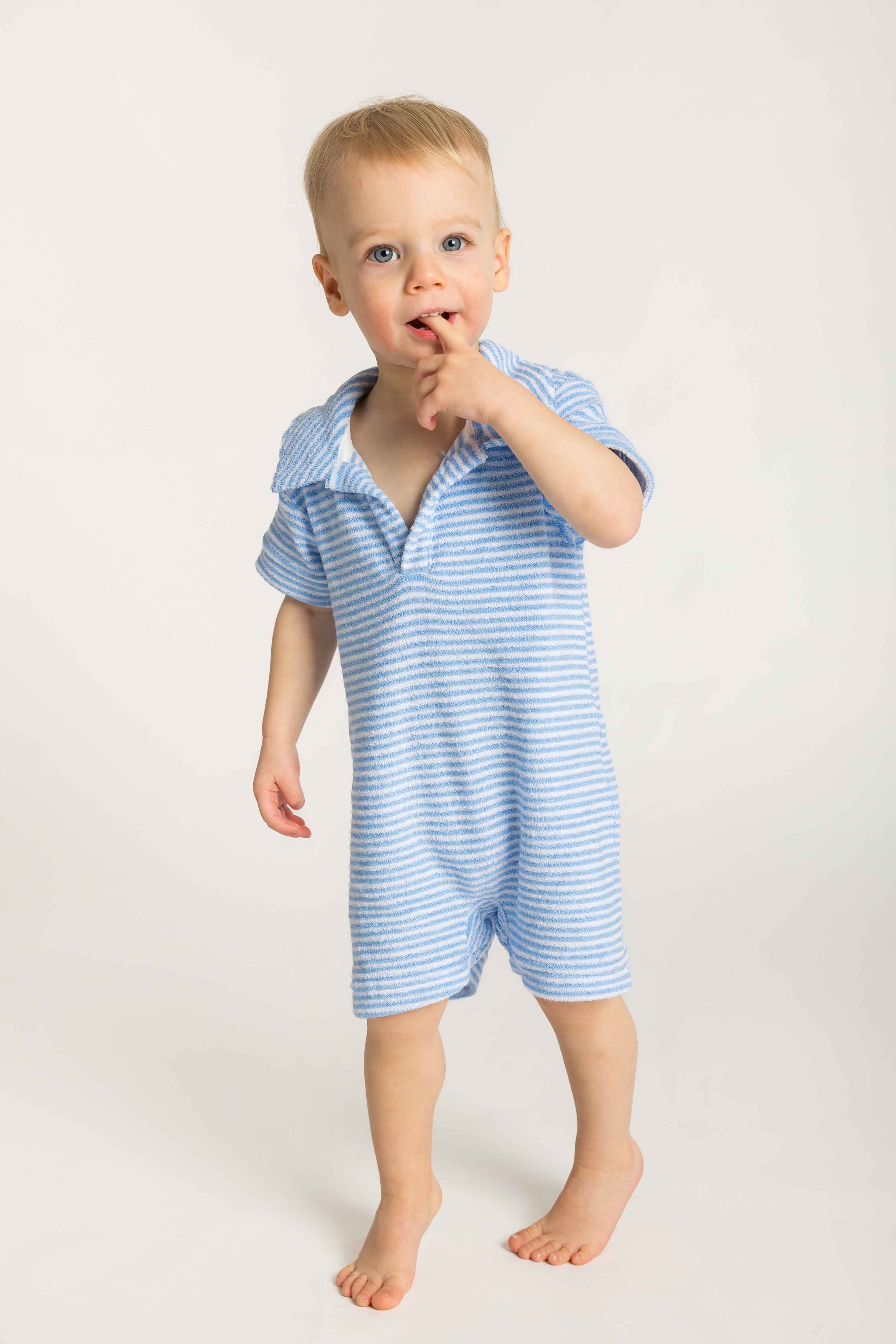 Child wearing a blue striped romper on a white background