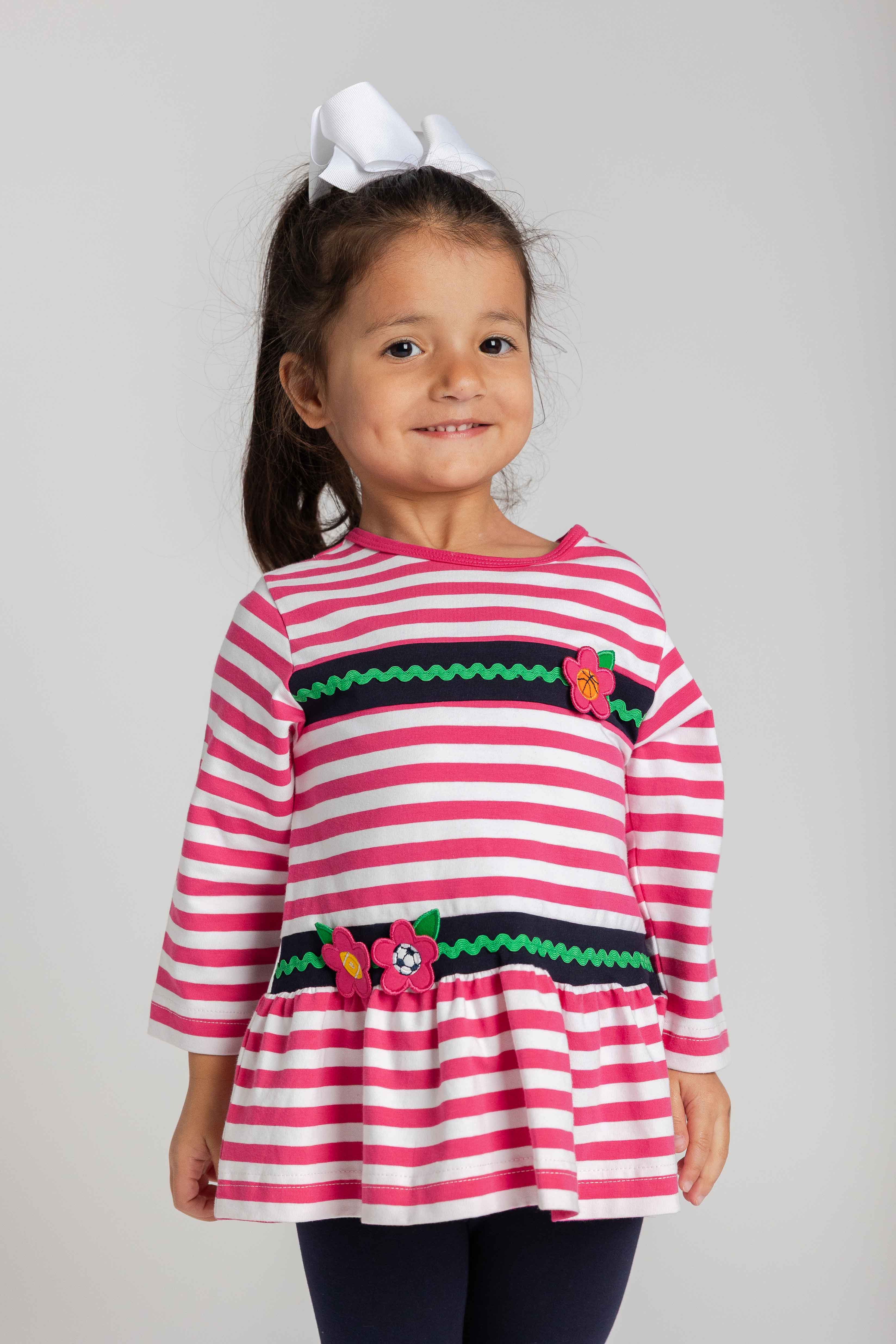 Young girl wearing a pink and white striped shirt with on a plain background