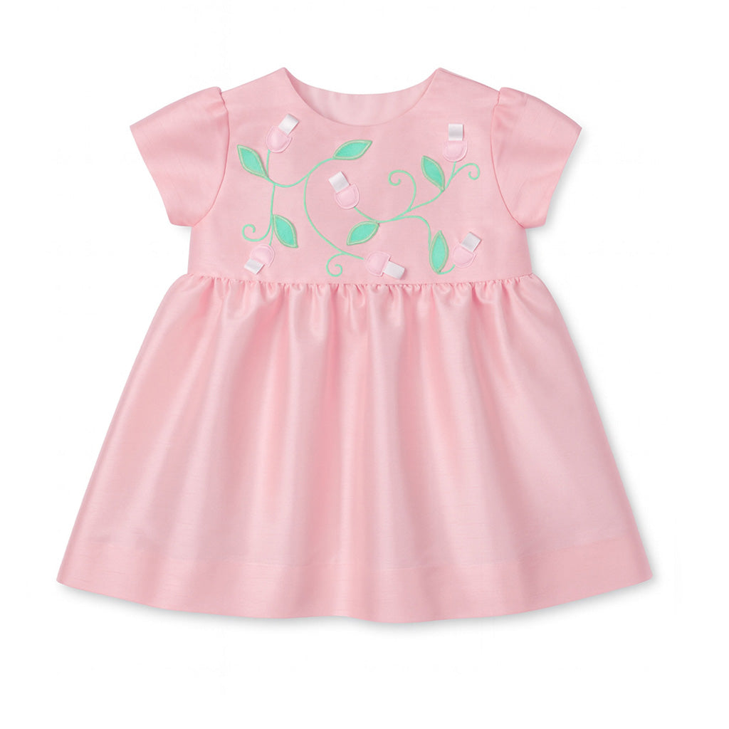 Pink baby dress with green floral embroidery on a white background