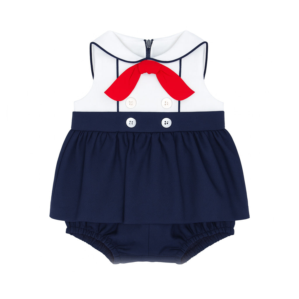 Navy blue baby romper with white top and red bow on a white background