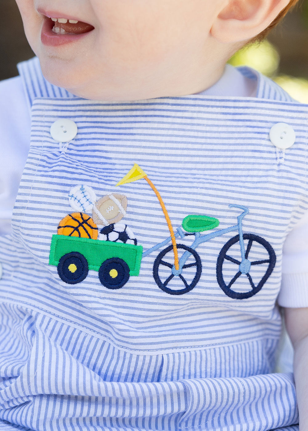 closeup of applique on toddler wearing seersucker shortall