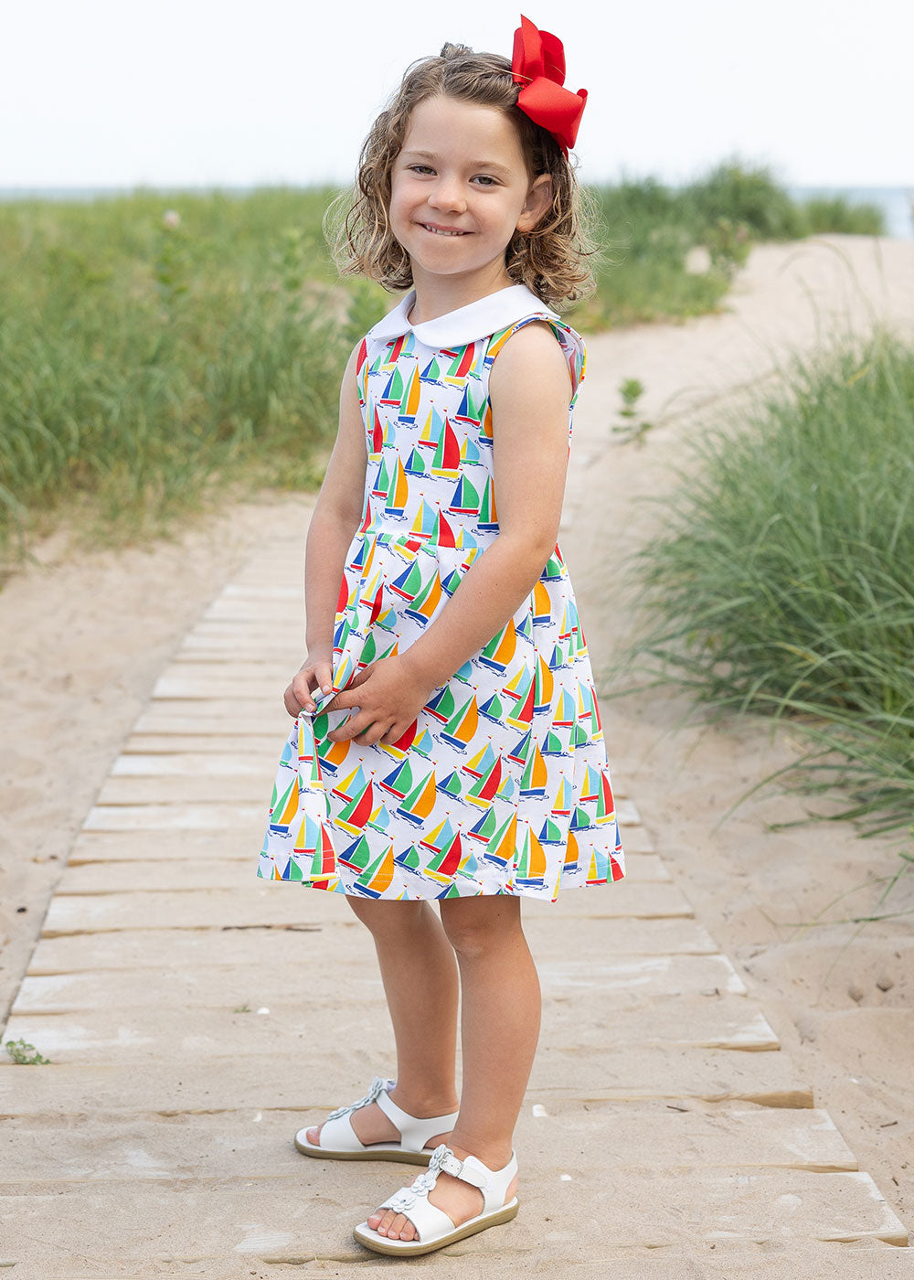 girl on boardwalk in sailboat twirl dress