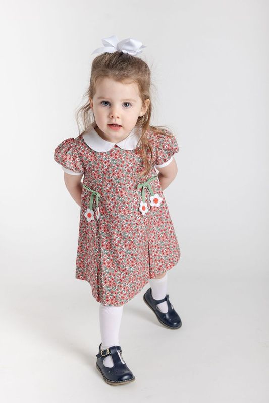 Young girl wearing a floral dress with a white collar