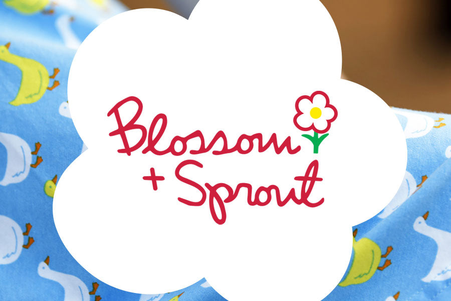 Image showing Blossom + Sprout logo over a white flower layered on top of duck pattern fabric