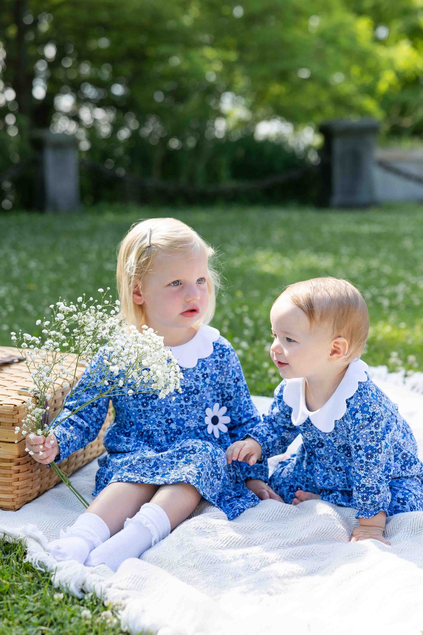 two young girls on blanket in yard