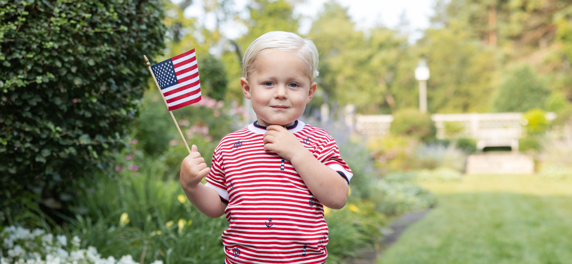 young boy in red stripe shirt with flag