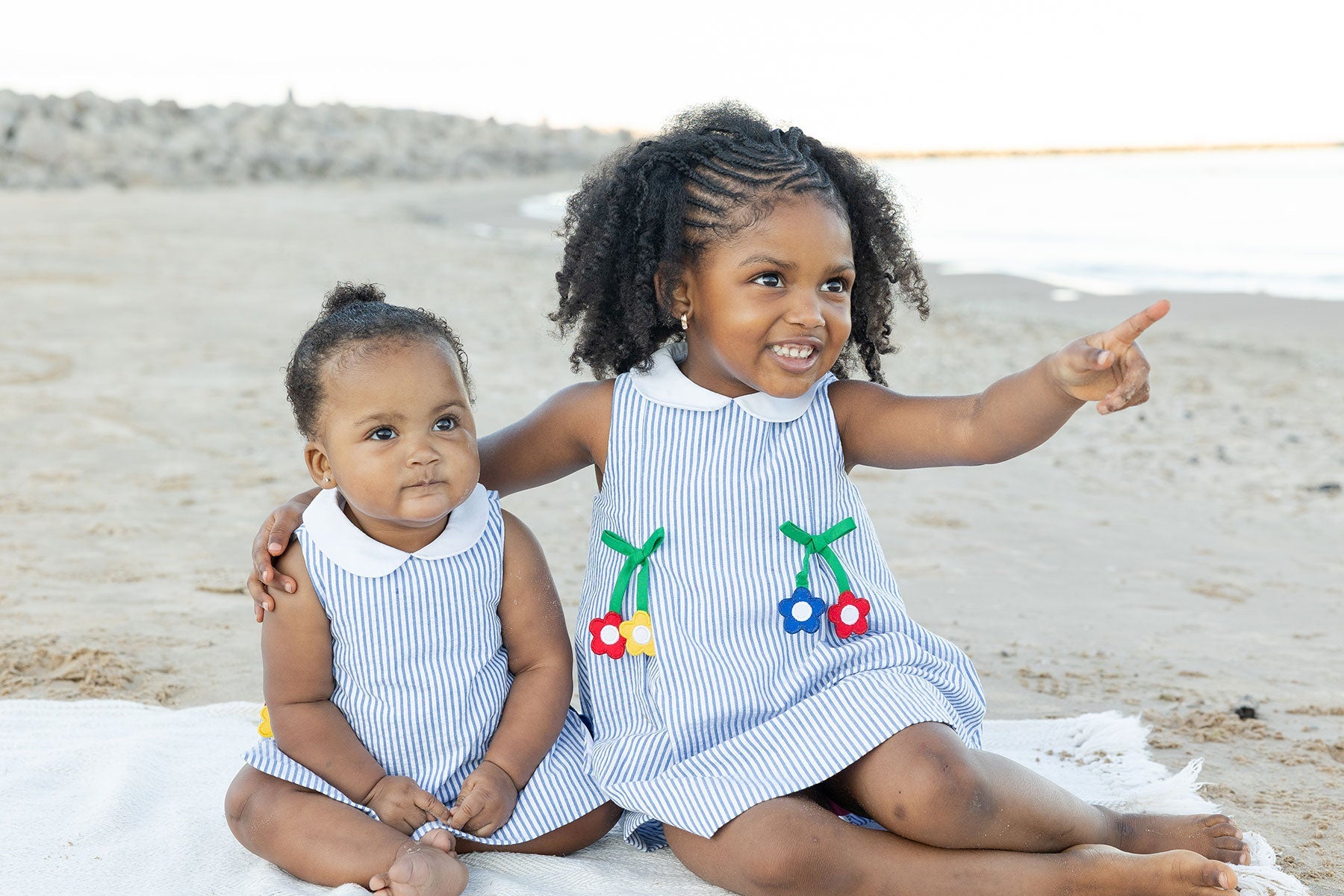 two children on a beach in fine clothing