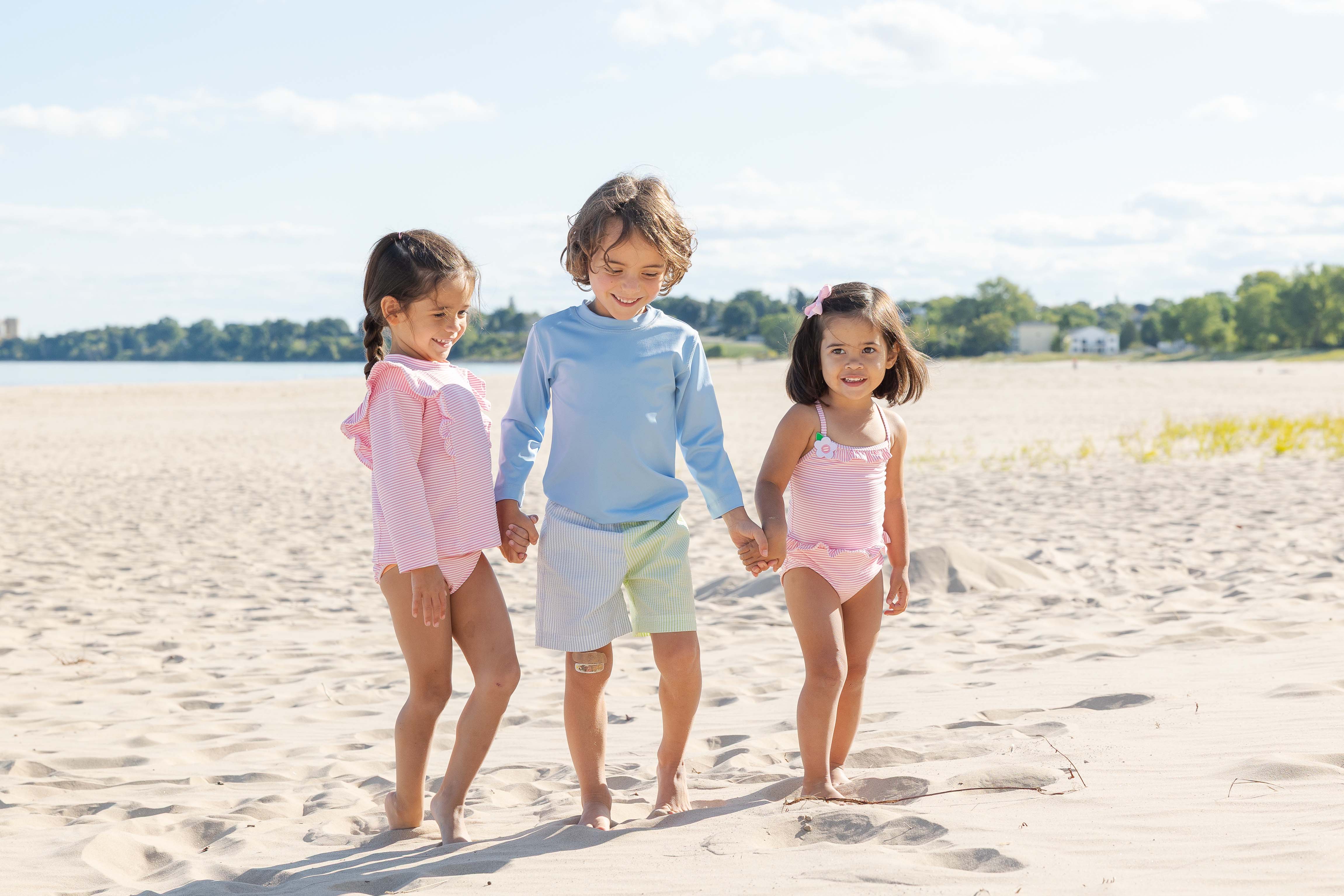 two young children in swimsuits on a beach blanket