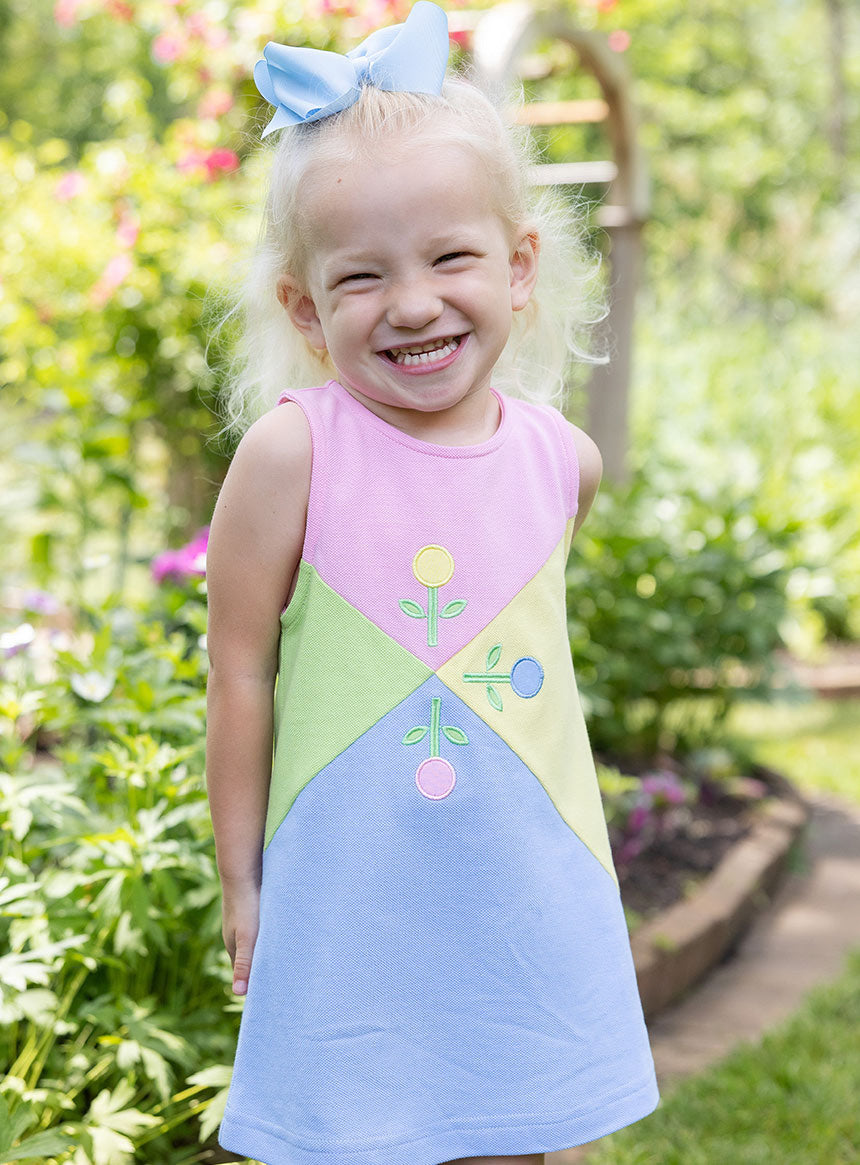 young girl in garden wearing jumper with flowers