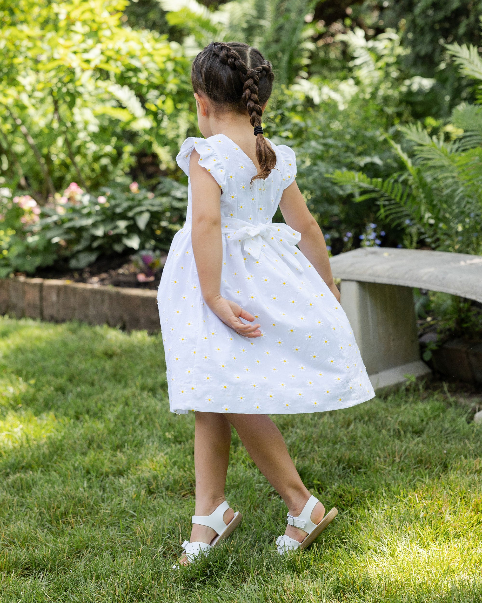 back view of girl in dress with daisies