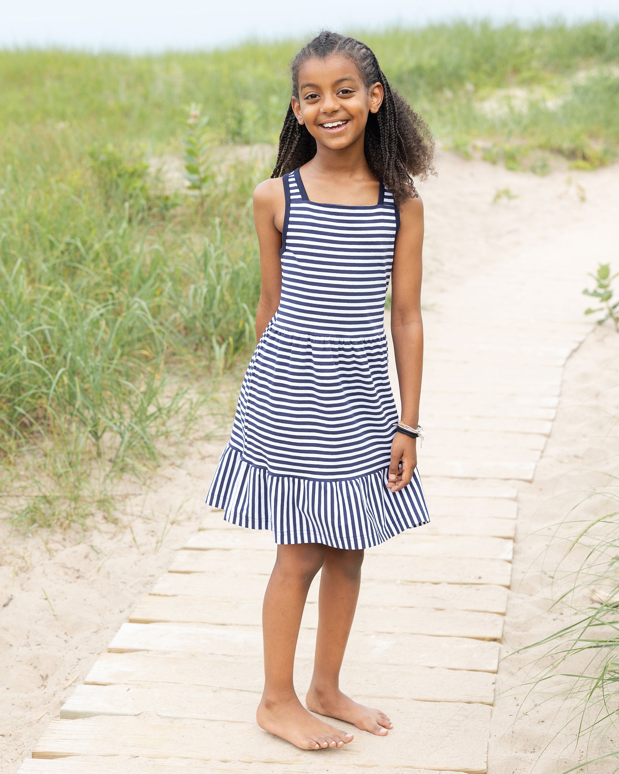 girl in navy stripe dress on beach