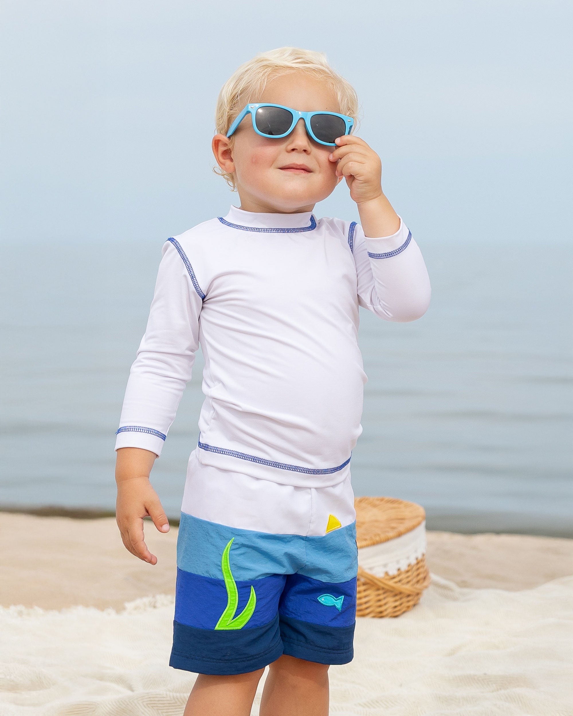 boy on beach in pieced fish swim trunk