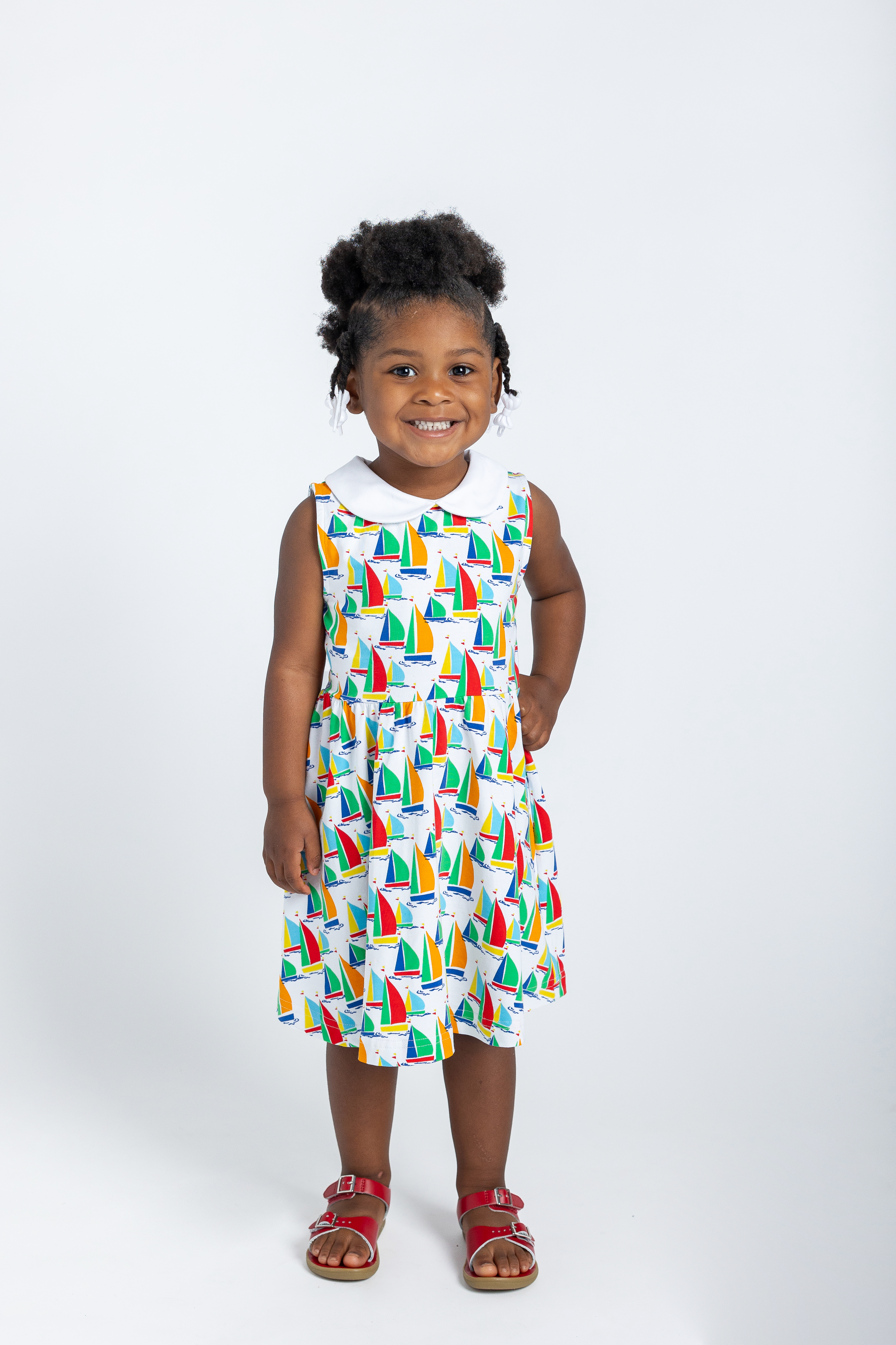 young girl in twirl dress with sailboats