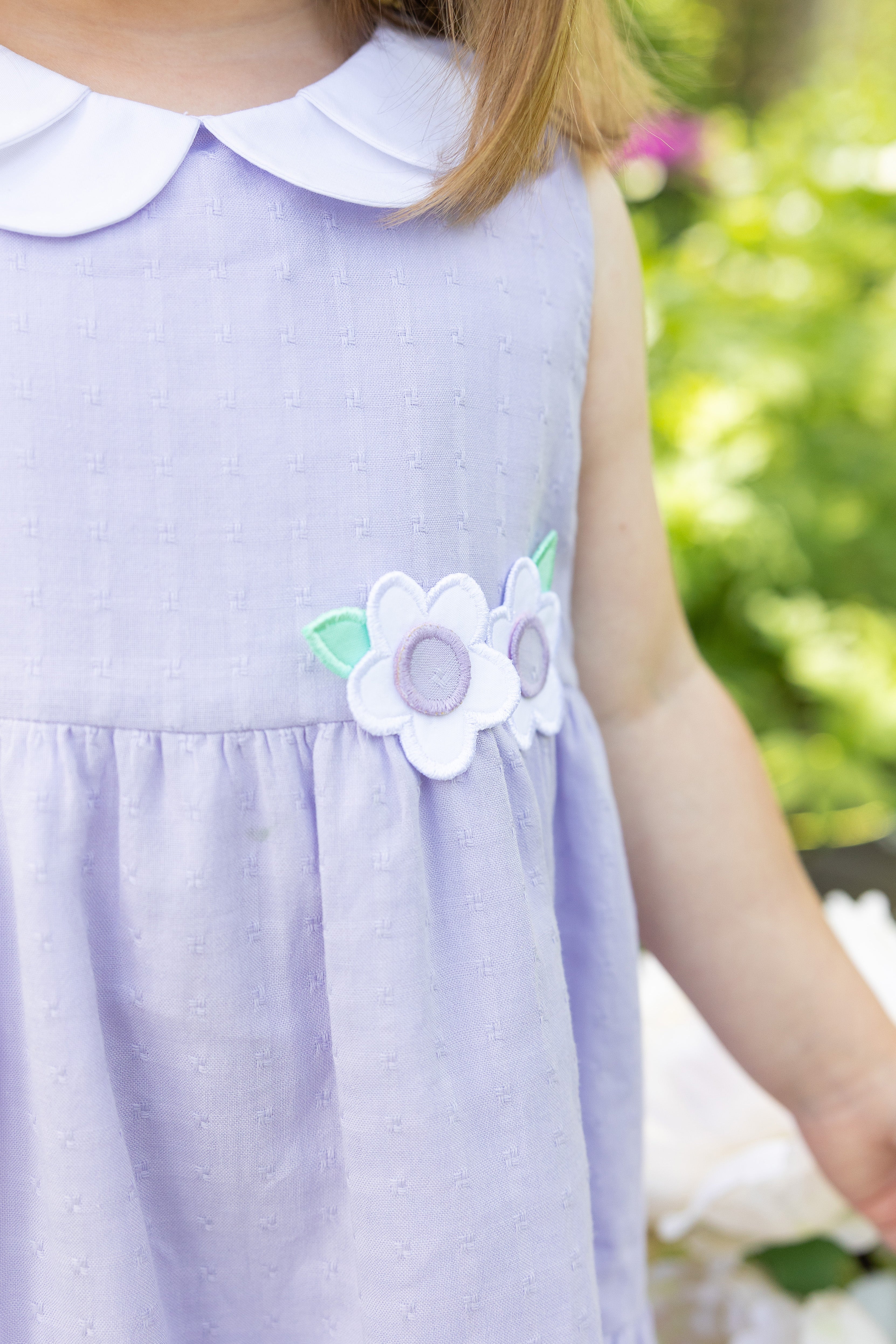 closeup of flower appliques on the lavender dress
