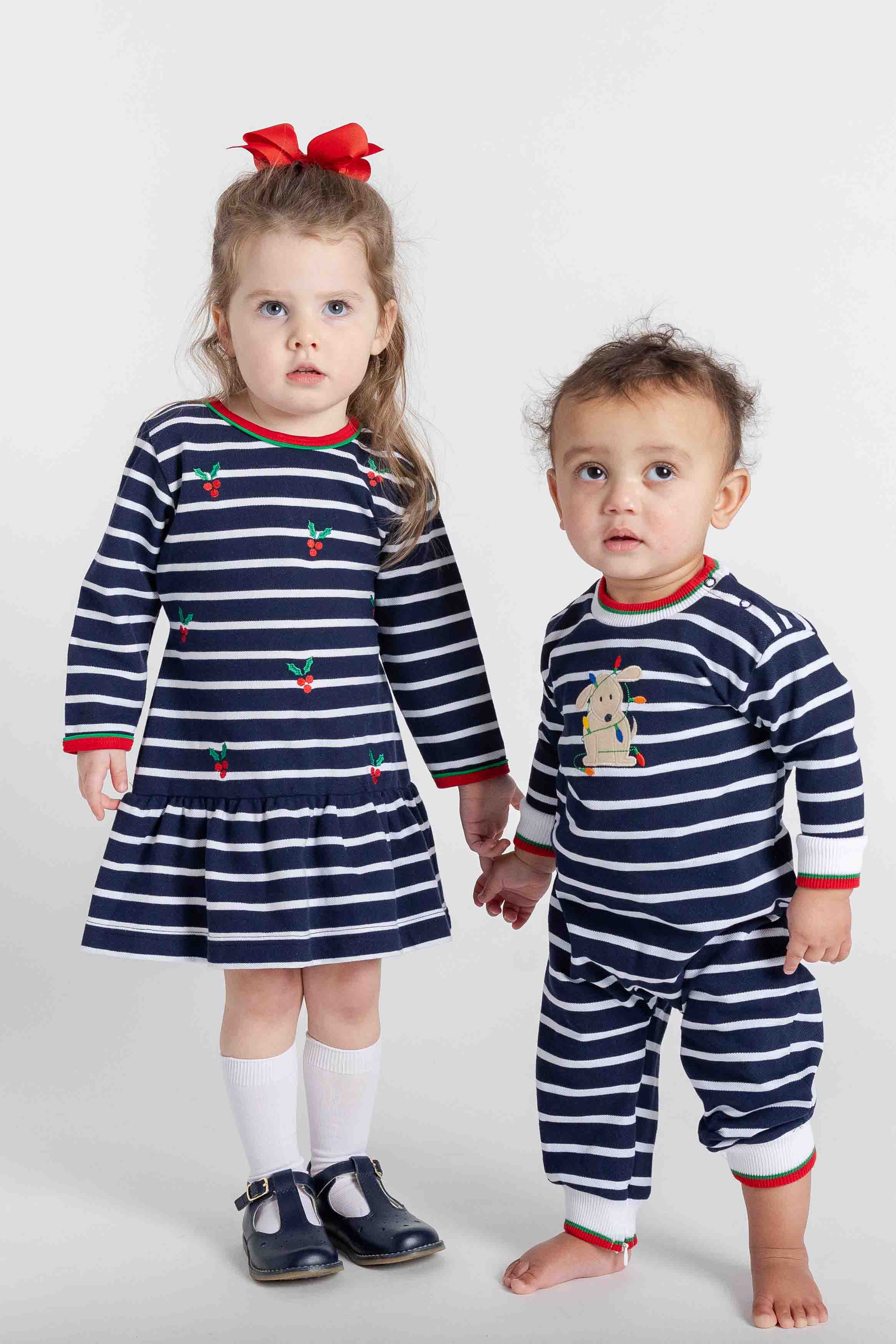 two children in navy and white stripe garments on a white background