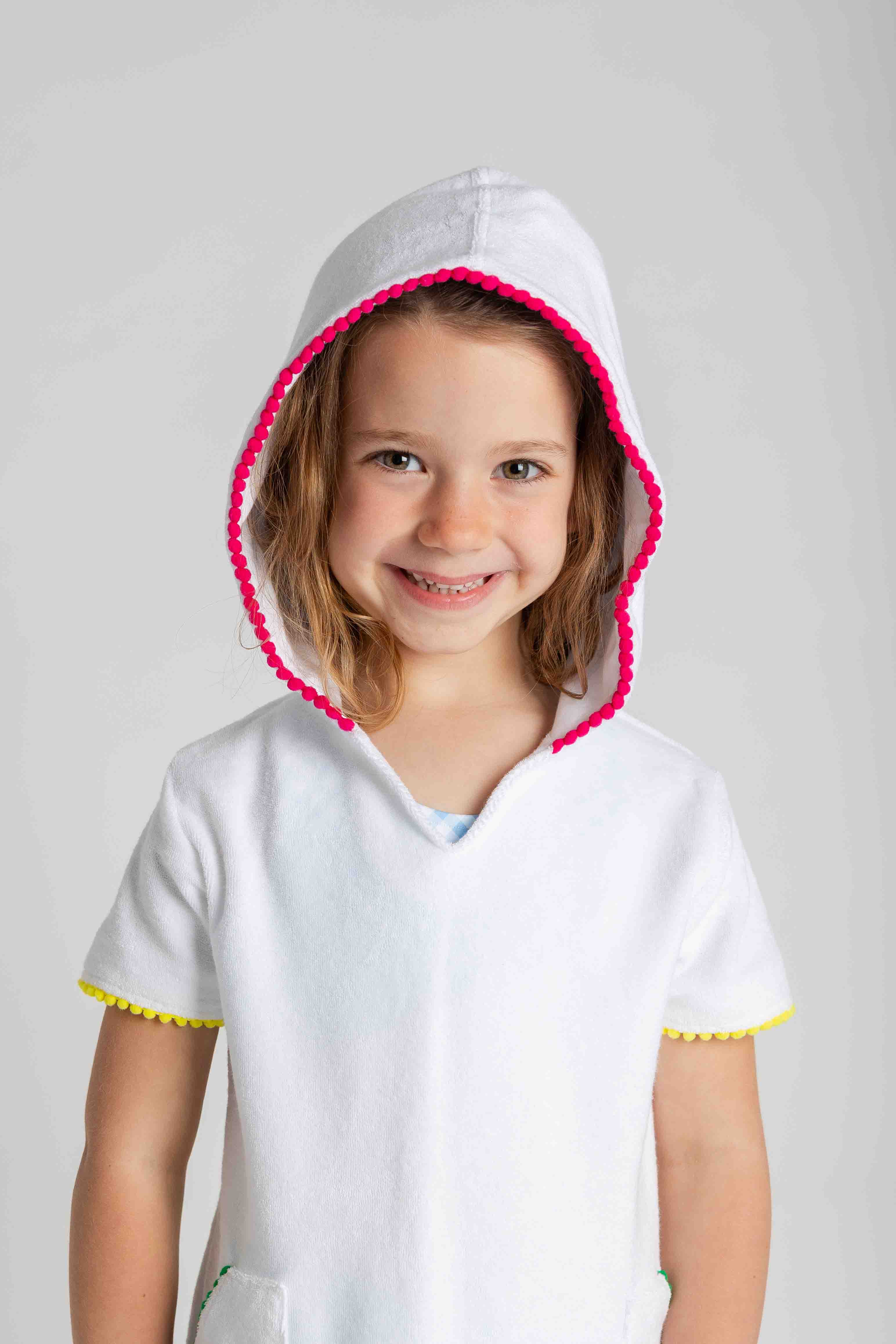 Child wearing a white hoodie with pink trim on a gray background