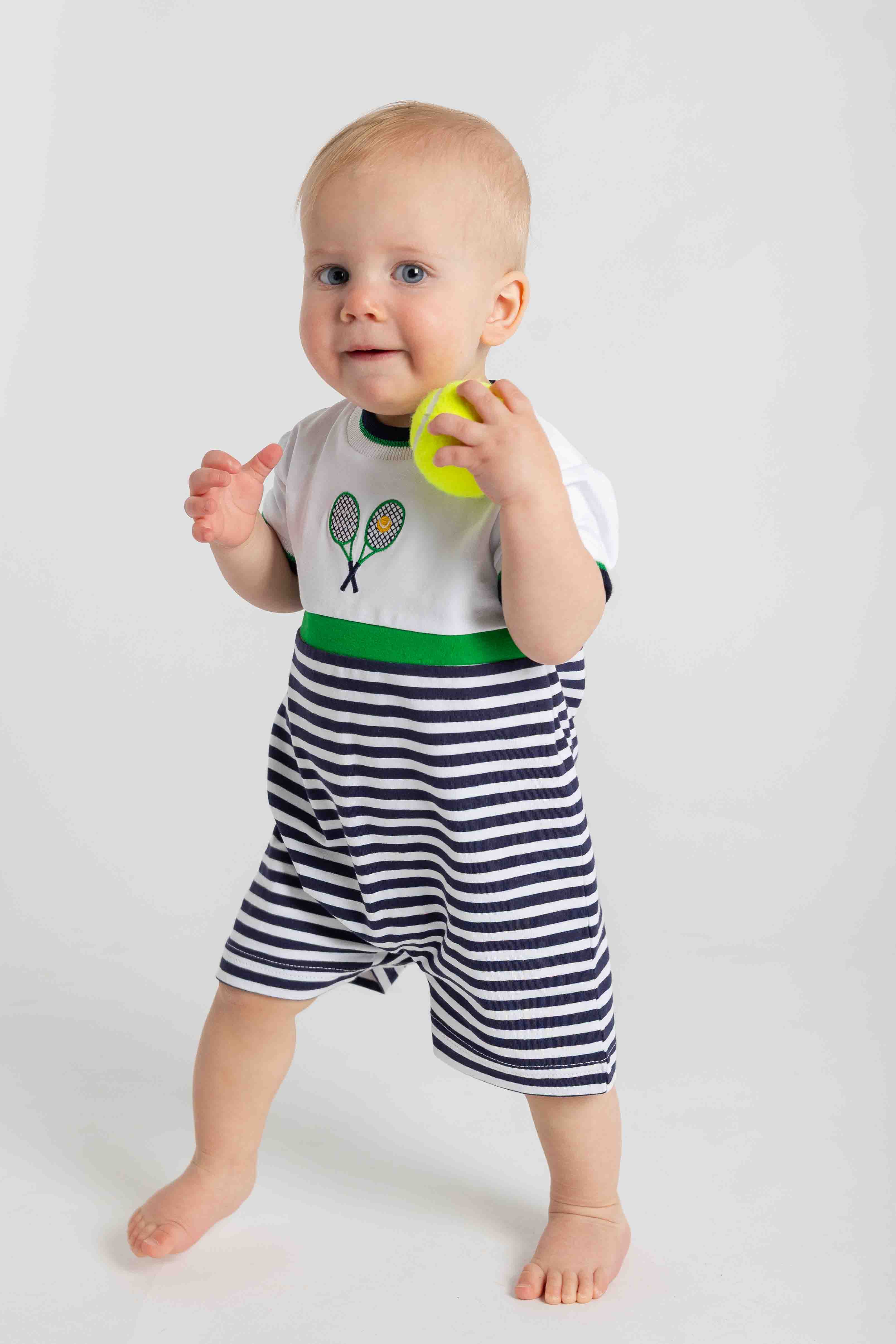 Baby wearing a striped outfit with a graphic top on a white background