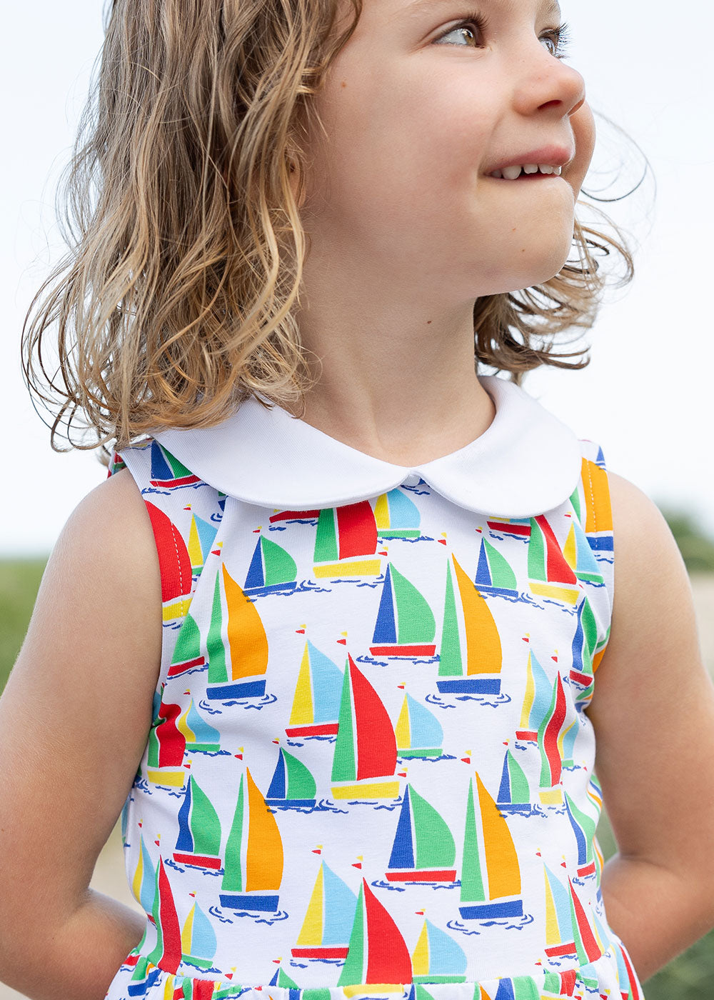 closeup of girl in twirl dress with sailboats