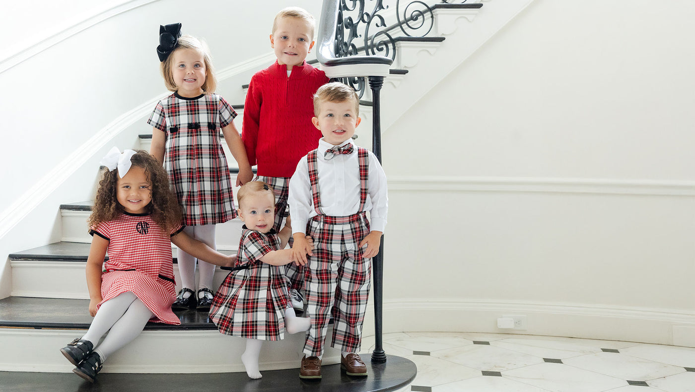 Five children in formal attire standing on a staircase.