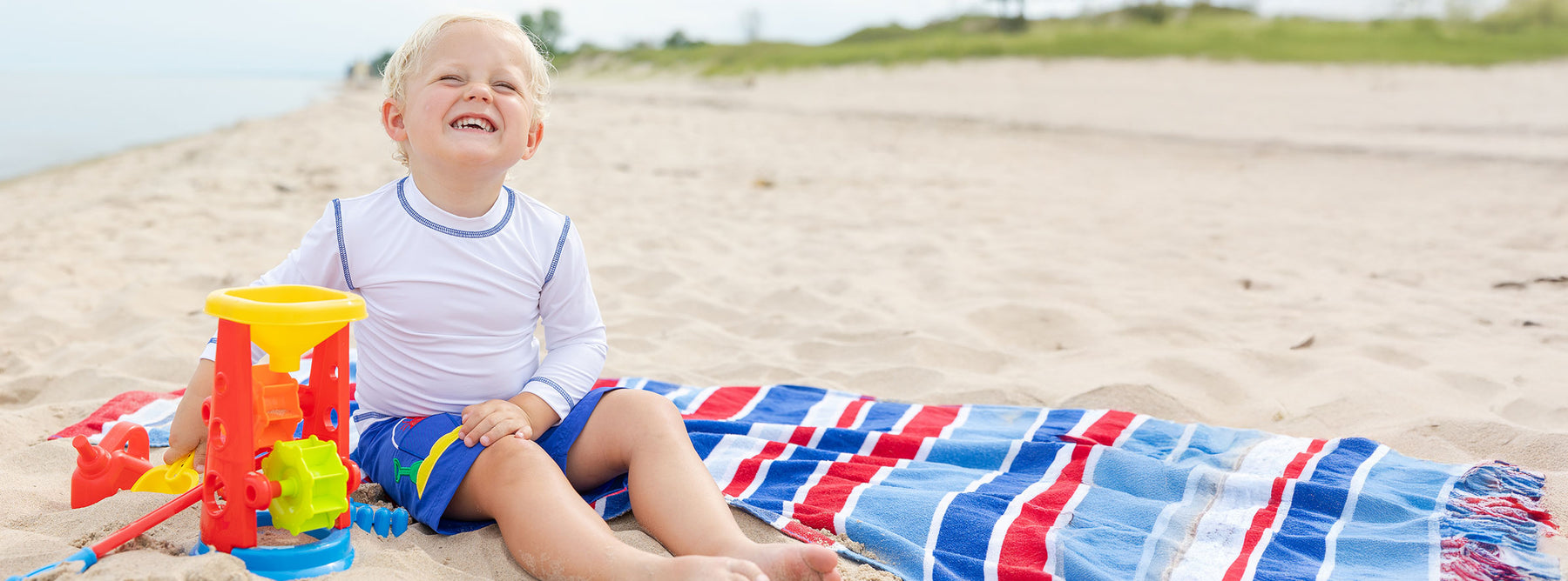 young boy playing in the sand on the beach