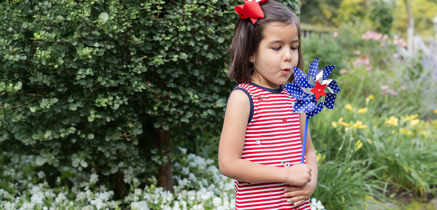 girl with pinwheel in red and white stripe top